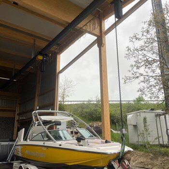 Electric chain hoists boat transport A boat is lifted from the boat trailer with chain hoists