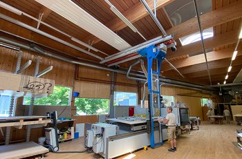 A GIS crane system with storage and retrieval unit ensures that the wooden boards are quickly and effortlessly transferred from the cantilever rack to the work table of the machine