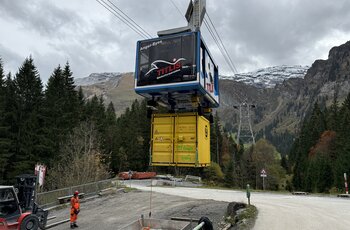 GIS underfloor loaded cabine system At the base station, the gondola picks up a container for under-load transport. The operator controls the process by radio control.