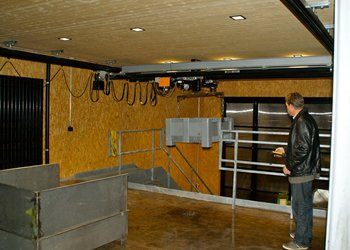 Ein Kunststoffgebinde wird vom GIS Elektrokettenzug schonend angehoben und vom Parterre zur Bühne im ersten Stock transportiert