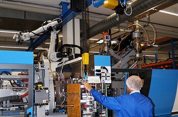 kran beim werkzeugwechsel Ein Werkzeug wird zur Spritzgussmaschine transportiert. Die präzise Positionierung erfolgt mittels frequenzgesteuerten Antrieben aller Achsen.