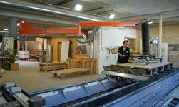 Wooden boards are transported in a carpentry workshop by means of a slewing crane