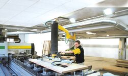 Gelenk-Drehkran mit Schlauchheber In Schreinerei werden Holzplatten mittels Drehkran befördert