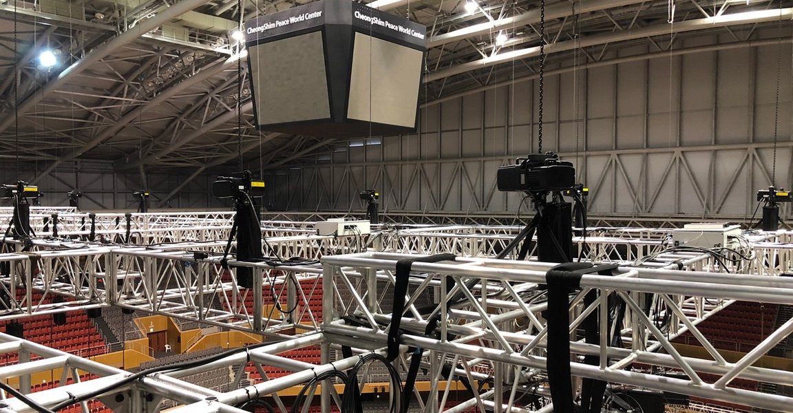 Electric chain hoists hold spotlights and loudspeaker systems in sports arena